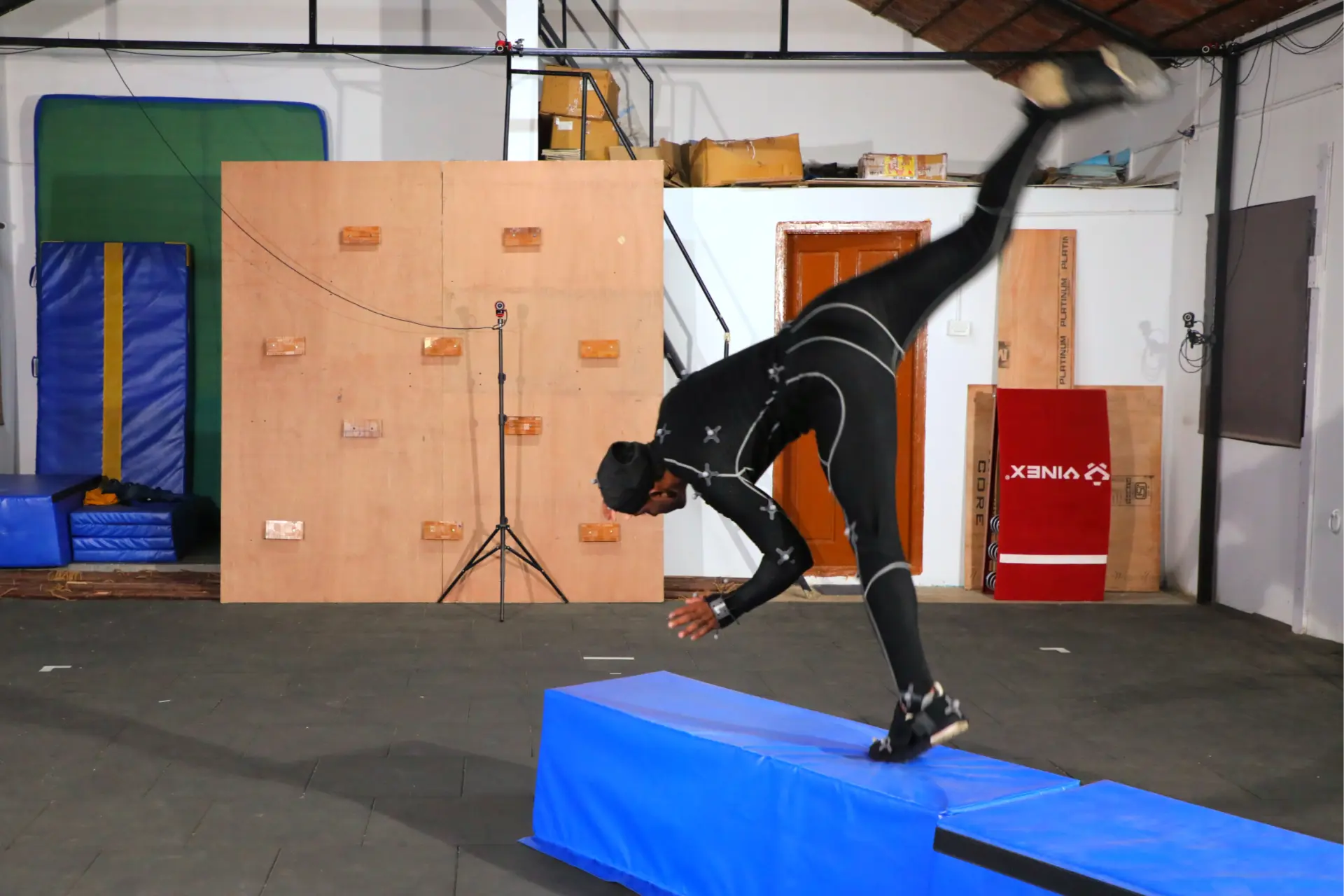 Performer in a marker suit vaulting on the mocap stage